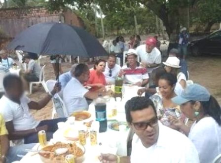 Camaçari: Funcionário segura guarda-chuva para prefeito durante almoço