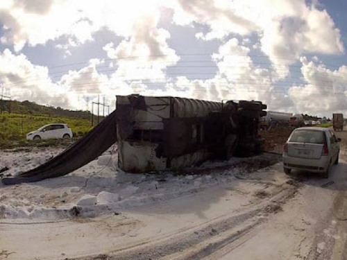 CARRETA TOMBA E ESPALHA CARGA NAS PISTAS DA BR-324.